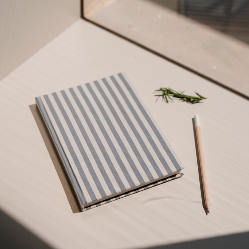 Detall d'una llibreta, llapis i tall de romaní Detalle de una libreta, lápiz y corte de romero Detail of a notebook, pencil and cut of rosemary